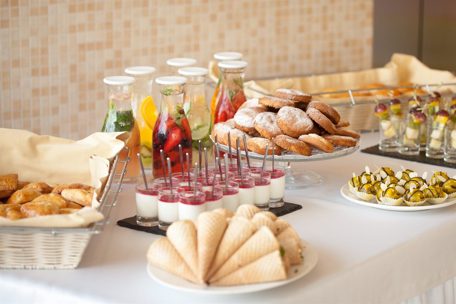 Mesa de coffee break com sucos, cookies e doces